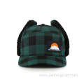 Warm winter cap with earflap green grip
